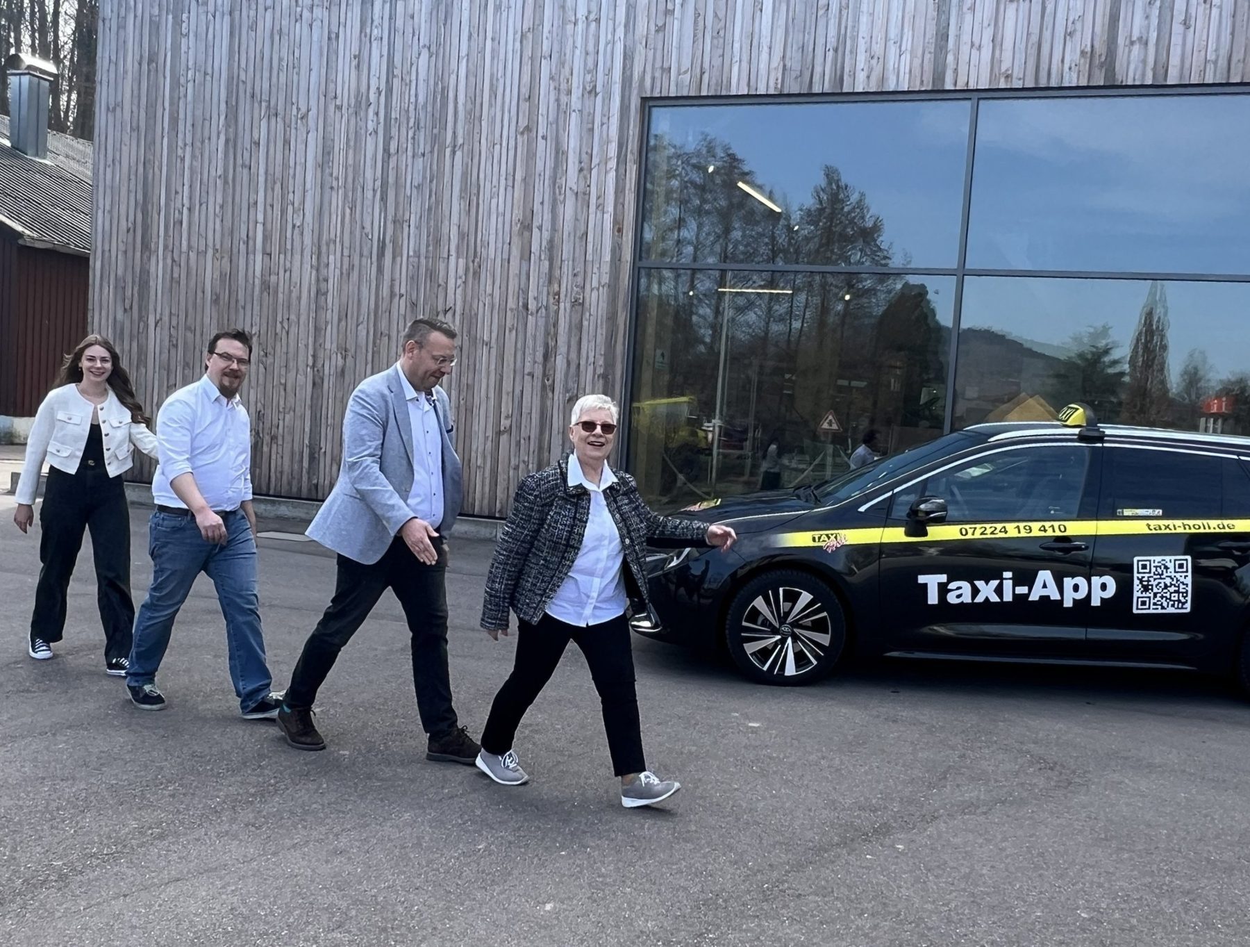 Edeltraud Holl geht voran, dahinter Dirk, Sebastian und Romy Holl, daneben ein Taxi von Taxi-Holl