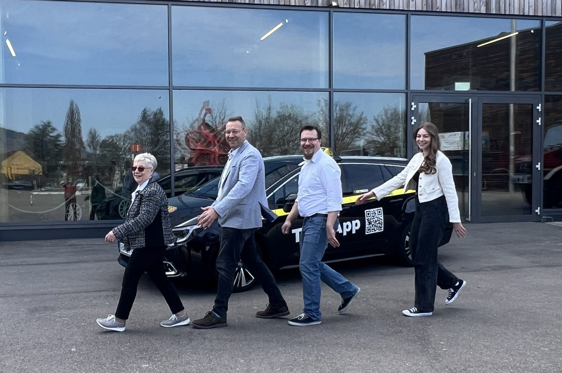 Edeltraud, Dirk, Sebastian und Romy Holl gehen lachend nebeneinander an einem Taxi vorbei