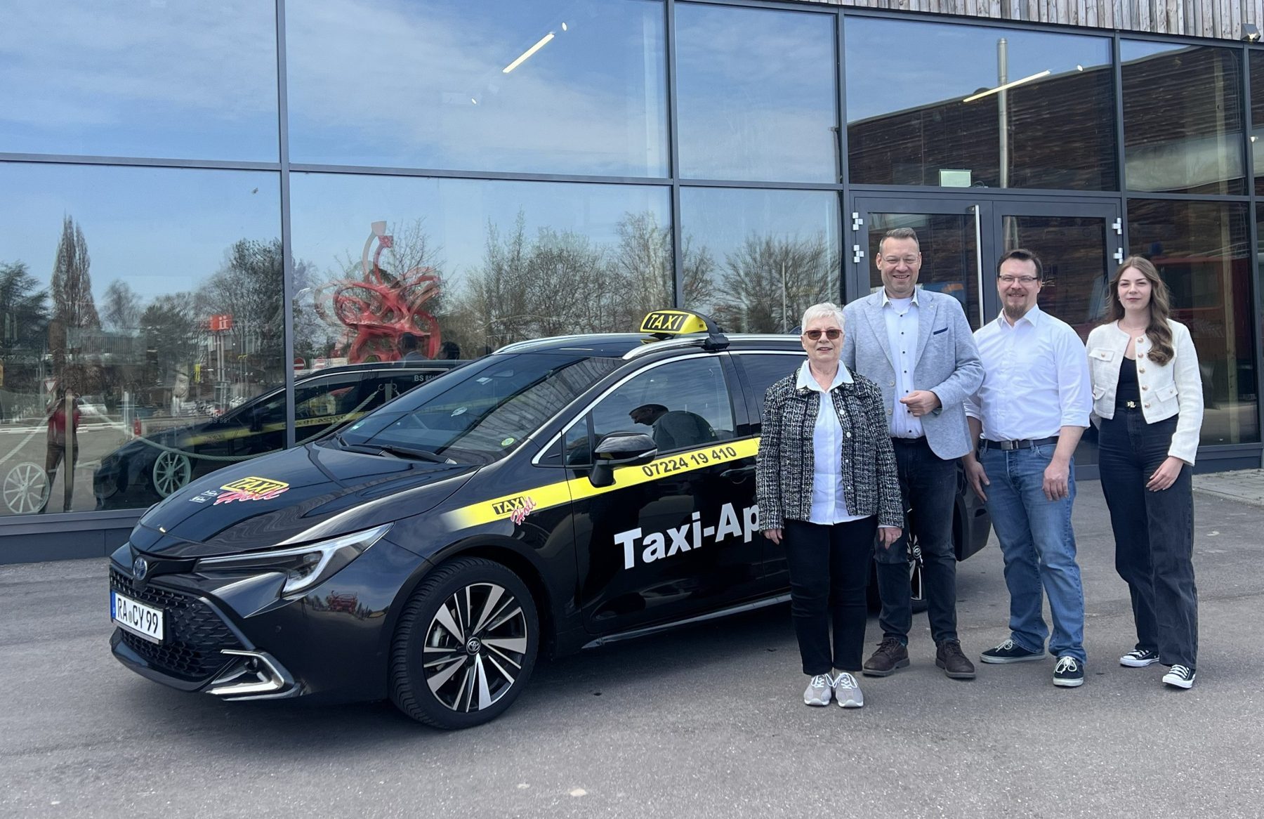 Edeltraud, Dirk, Sebastian und Romy Holl neben einem Taxi von Taxi-Holl
